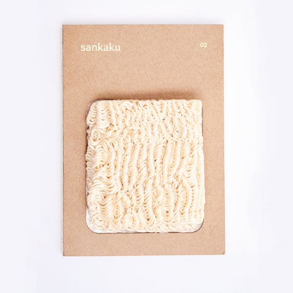 The Sankaku Vol. 02: Ramen book, featuring vacuum packed real instant ramen noodles as part of its cover. On show at NiMi Projects UK.
