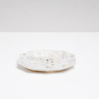 A side view of a Buoy recycled plastic polygon-shaped soap dish in mottled white, made of marine waste plastic collected from the shores of Japan.Edit alt text