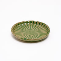 Side view of a NiMi Projects' Hana Akari Mino-yaki Japanese porcelain small plate, glazed in green.