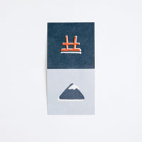 A blue Japanese Motif Mini Card, laid flat to show both sides, with one side showing picture of Mount Fuji topped with white snow, and the other side featuring an illustration of a red torii gate on a darker blue background. Printed in Japan and available at NiMi Projects.