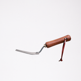 Side view of Asano Mokkousho's stainless steel garden fork, with walnut handle and leather hanging strap, made in Niigata's Tsubame-Sanjo metalworking area and available at NiMi Projects UK.