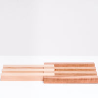 An expandable trivet of Hinoki (Japanese Cypress) and Cherry Wood slats, opened up with the hinoki slats on the left and the cherry wood slats on the right. Crafted in Japan by Tosa Ryu  and available at NiMi Projects UK.
