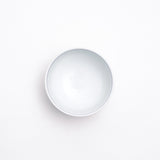 Top view of a white vintage Japanese porcelain teacup, featuring a blue line detail inside the rim.