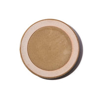An aeriel view of a mino-yaki earthenware small plate, designed by Angle and made in Japan, featuring a central circle of glossy taupe glaze and a matching line of taupe on its outer rim. An exposed, unglazed clay border of the plate showcases the speckled texture of the raw orange clay. Image courtesy of Angle.