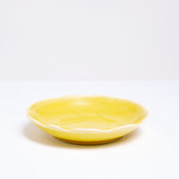 A Mino-yaki Japanese porcelain plate with fluted edge in bright yellow. On show at NiMi Projects UK.