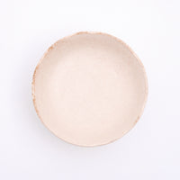 Top view of a Mino-yaki Japanese porcelain plate with fluted edge in a creamy off-white. On show at NiMi Projects UK.