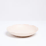 A Mino-yaki Japanese porcelain plate with fluted edge in a creamy off-white. On show at NiMi Projects UK.