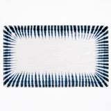 An aerial view of the rectangular Mino-Yaki Tokusa Sushi Plate, available at NiMi Projects, made of white porcelain and featuring a traditional Japanese horsetail grass pattern of indigo-blue zig-zag stripes that taper inward around the edge like a frame.