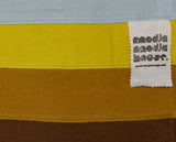 Close up of a brown and yellow striped section of Amy Croft's hand-crafted, contemporary Japanese noren curtain, showing the brand's Modja Modja House label. The label is a white piece of fabric  stamped with the logo in black, sewn into one of the noren's hidden seams. Designed and handcrafted by Amy Croft and on show at NiMi Projects UK. Image ©Amy Croft.