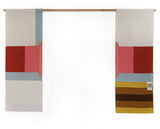 A contemporary-style Japanese noren curtain, split into two separate rectangular panels that are displayed on a wooden pole. The left panel features a white background with central red and pink rectangles above a pale blue horizontal stripe, and a pale vertical stripe in the top right. The right panel has matching pink, red and blue rectangles, with yellow and brown stripes below it.  Designed and hand made by Amy Croft, Modja Modja House, and available at NiMi Projects UK. Image ©Amy Croft.