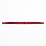A pair of red ryokuchi (double-end tapered) wooden chopsticks (hashi) made in Japan, on a white background. By Style of Japan and available at NiMi Projects UK.