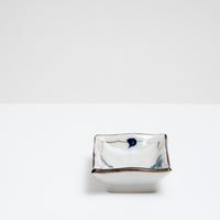 A small Japanese vintage porcelain dish.  It features a border design of blue underglaze bunches of grapes and vine leaves and a crackle glaze.