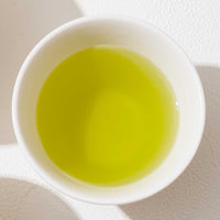 View from above of  a white porcelain cup filled with vibrant Iro Kabusecha Japanese green tea. ©AWAIDO