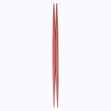 A pair of red ryokuchi (double-end tapered) wooden chopsticks (hashi) made in Japan, on a white background. By Style of Japan and available at NiMi Projects UK.
