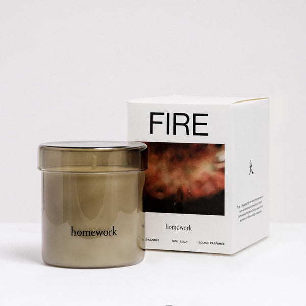 Candle labeled 'homework' next to its packaging on a white background