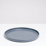 A side view of a large, round Kihon no Utsuwa blue, Japanese porcelain dinner plate. Made in Japan from recycled ceramics and local clays and available at NiMi Projects UK.
