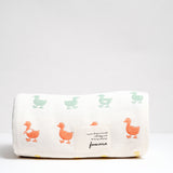 A rolled up off-white Japanese gauze muslin blanket with a pattern of rows of multicolour duck motifs. Made in Japan by Fuwara and on show at NiMi Projects UK.