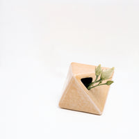 A Japanese ceramic, diamond-shaped bud vase in yellow, holding a sprig of white floer buds. Available at NiMi Projects UK.