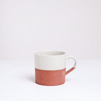 An earthenware mug half-dipped from the top in a silky white glaze. Made in Japan by Angle ceramics and pictured at NiMi Projects UK.