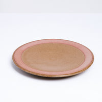 A mino-yaki earthenware small plate, designed by Angle and made in Japan, featuring a central circle of glossy taupe glaze and a matching line of taupe on its outer rim. An exposed, unglazed clay border of the plate showcases the speckled texture of the raw orange clay. Available at NiMi Projects UK.