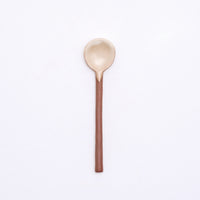 A mino-yaki earthenware tea spoon made in Japan by Angle and available at NiMi Projects UK. Its handle is left as exposed orange clay, while its head has been dipped in a satin white glaze.