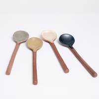 Four mino-yaki earthenware ceramic tea spoons, laid out on a white background at NiMi Projects UK. Designed by Angle ceramics and made in Japan, each spoon features a raw exposed orange clay handle and a head that has been dipped in a rustic coloured glaze. From left to right: a grey version, yellow, white and graphite black. 