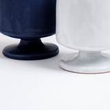Closeup of the feet of a blue and a white, satin-glazed stemmed mug with a round base. Hand made in Japan by Angle and available at NiMi Projects UK.