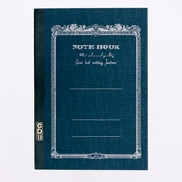 A navy blue Apica note book, showing an arabesque border printed in black with the words "Notebook" and "Most advanced quality Gives best writing features." Its spine is bound in black with a gold CD11 stamp. Made in Japan and available at NiMi Projects UK.