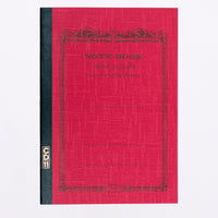 A red covered Apica note book, showing an arabesque border printed in black with the words "Notebook" and "Most advanced quality Gives best writing features." Its spine is bound in black with a gold CD11 stamp. Made in Japan and available at NiMi Projects UK.