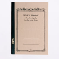 A cream Apica note book, showing an arabesque border printed in black with the words "Notebook" and "Most advanced quality Gives best writing features." Its spine is bound in black with a gold CD11 stamp. Made in Japan and available at NiMi Projects UK.