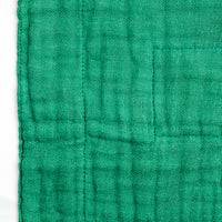 Close-up of a forest green Ban Inoue, Japanese muslin dishcloth, showing its woven texture.