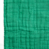 Close-up of a forest green Ban Inoue, Japanese muslin dishcloth, showing its woven texture.