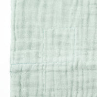 Close-up of a Ban Inoue, mint green, Japanese muslin dishcloth, showing detail of its weave.