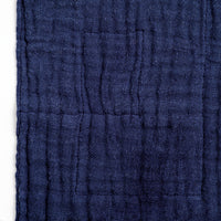 Detail of a navy blue, Ban Inoue, Japanese muslin dishcloth, showing its crumpled woven texture.