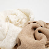 Two soft, textured woven organic cotton, muslin kitchen cloths in natural-white and clove brown, arranged in a close-up studio composition. Made by Ban Inoue in Japan and available at NiMi Projects UK.