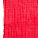 Detail of the textured red Japanese muslin  fabric of a Ban Inoue dishcloth.