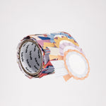 A roll of multicolored washi tape stickers shaped like rosettes. Each rosette is patterned differently and layered on top of the one before to create the roll. Available at NiMi Projects UK.