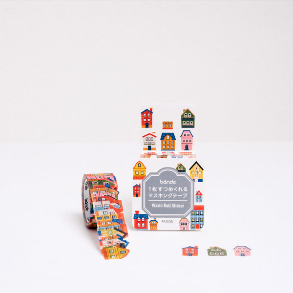 A roll of Japanese washi paper tape house stickers, each featuring a different little house or mansion. Pictured with its packaging and available at NiMi Projects UK.
