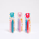 A group of three sets of Sakura Coupy Dry crayon highlighters at NiMi Projects UK. From left to right: A pack of retro  colours (pink, turquoise and yellow), a pack of milky pastels (lilac, pink and yellow), and a pack of pop colors (blue, red and bright yellow)