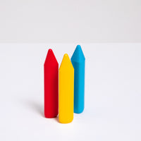  A group of three pop color, triangular, Sakura Coupy dry highlighter crayons at NiMi Projects UK. From left to right  the  colors are red, bright yellow and sky blue.