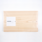 A large rectangular Hinoki Japanese cypress chopping board with a smooth, pale wood finish, shown from above with its white product label. Available at NiMi Projects UK.