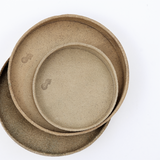 Ariel view of a stack of beige coloured, up-cycled, skived split leather trays. Each tray is round and molded into shape by Rhythmos in Japan. Available at NiMi Projects UK.