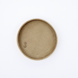 Ariel view of a small round, green-beige Rhythmos, up-cycled, skived split leather tray. The tray has been molded into shape by Japanese leather artisans and is available at NiMi Projects UK.