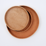 Ariel view of a stack of Rhythmos, up-cycled, natural brown, skived split leather trays, each round and molded into shape by Rhythmos in Japan. Available at NiMi Projects UK.