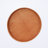 Ariel view of a large, round Rhythmos, up-cycled, natural brown, skived split leather trays. The tray has been molded into shape by Japanese leather artisans and is available at NiMi Projects UK.