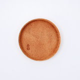 Ariel view of a small round, natural brown Rhythmos, up-cycled, skived split leather tray. The tray has been molded into shape by Japanese leather artisans and is available at NiMi Projects UK.