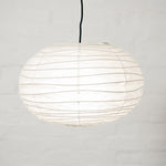 A Saiko Design Japanese washi paper Cloud lampshade  in white, on display at NiMi Projects UK. Oval in shape, its frame is constructed using traditional chochin lantern techniques and wraps around the form in wavy lines.