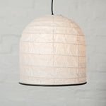 A white Saiko Design Yama Japanese  washi paper lampshade on show at NiMi Projects UK. Named after the Japanese word  for "mountain,"  its form is like that  of  a bell. The framework holding out its shape is made using traditional Japanese  chochin lantern techniques.