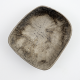 Top view of a rectangular Chinaberry wood bowl, showing the texture of its hand-chisel carving, and finished in urushi silvery grey lacquer with a shimmery dusting of fine tin powder. On show at NiMi Projectes UK, and made by Japanese artisan Solmu Puu from wood collected in Yakushima.