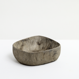 Side view of a rectangular Chinaberry wood bowl, showing the texture of its hand-chisel carving, and finished in urushi silvery grey lacquer with a shimmery dusting of fine tin powder. On show at NiMi Projectes UK, and made by Japanese artisan Solmu Puu from wood collected in Yakushima.
